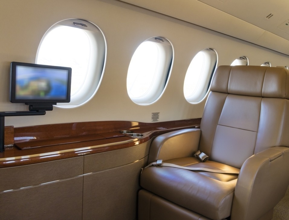 Large business jet cabin with empty seat and monitor