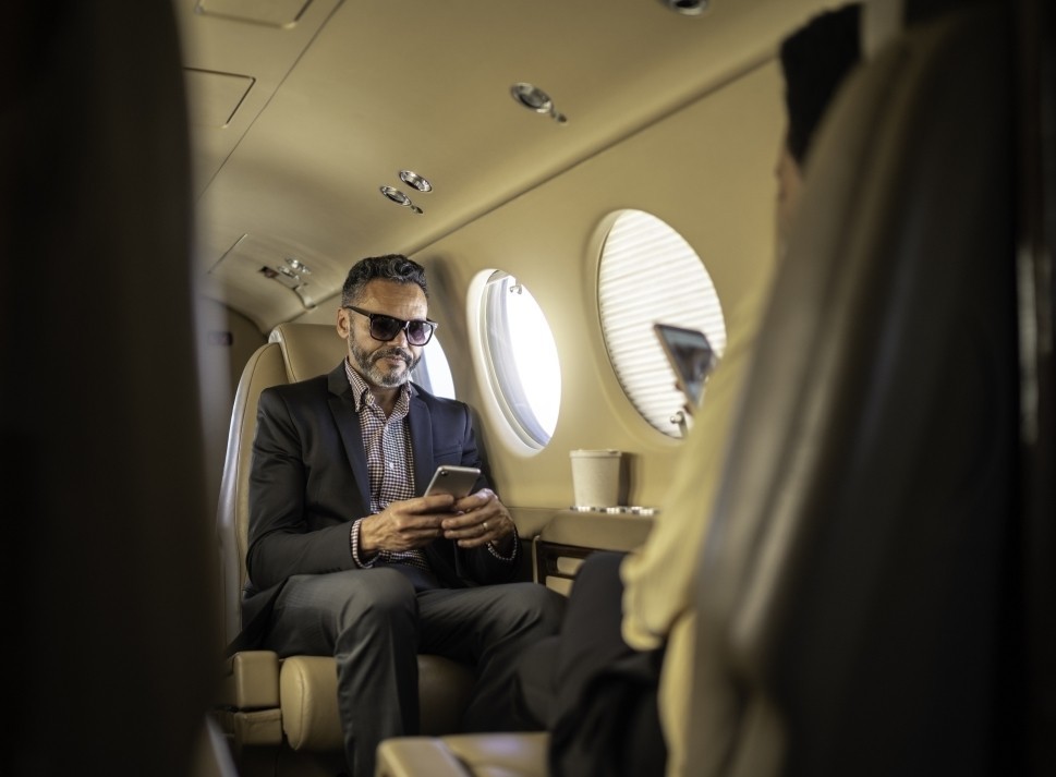 Executives on a Beechcraft King Air use their phones in-flight