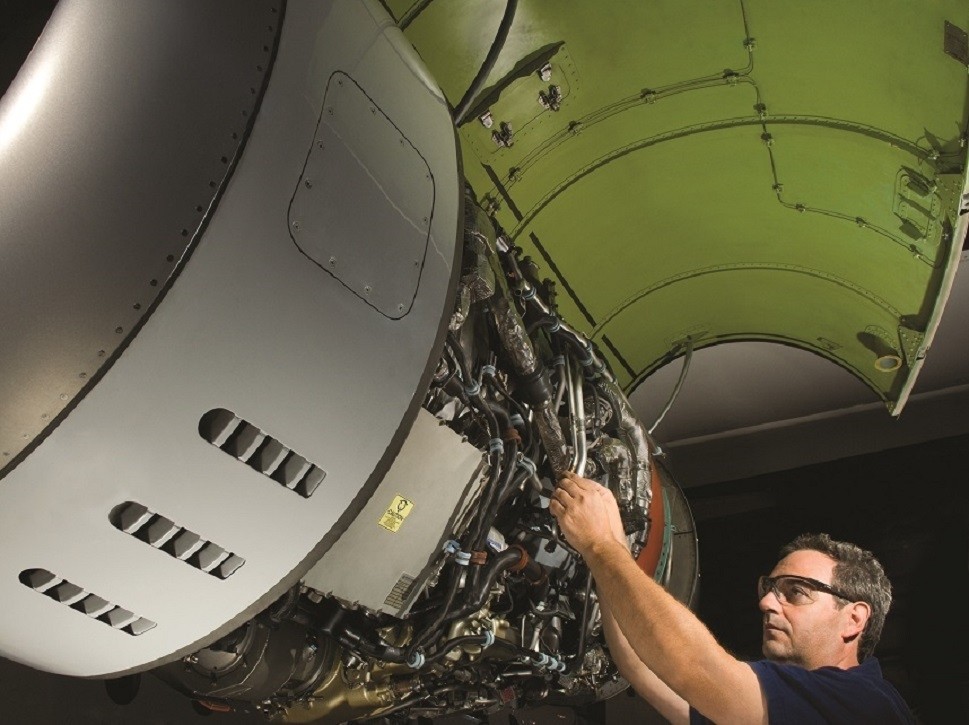 MRO worker performing maintenance on a Pratt & Whitney jet engine