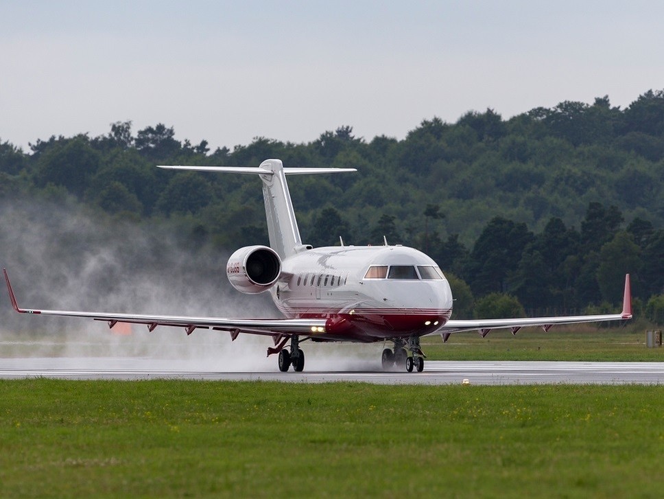 Bombardier Challenger 605 jet touches down in the rain