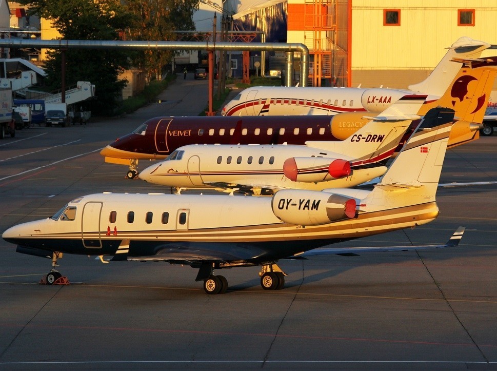 Older private jets parked next to each other on an airport ramp