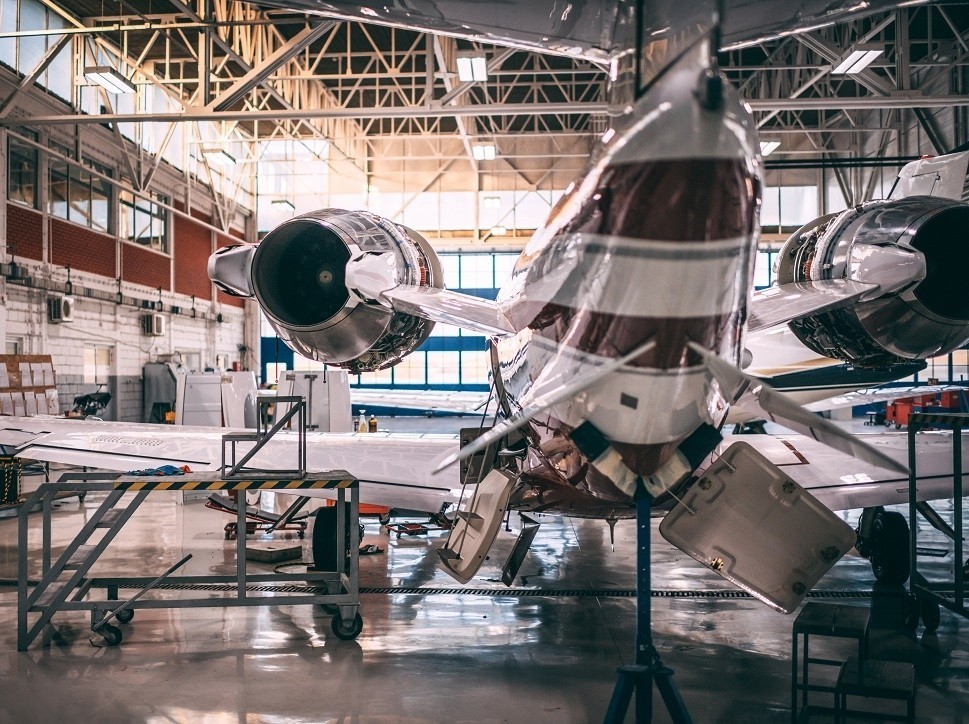 A private jet undergoes maintenance in an MRO shop hangar