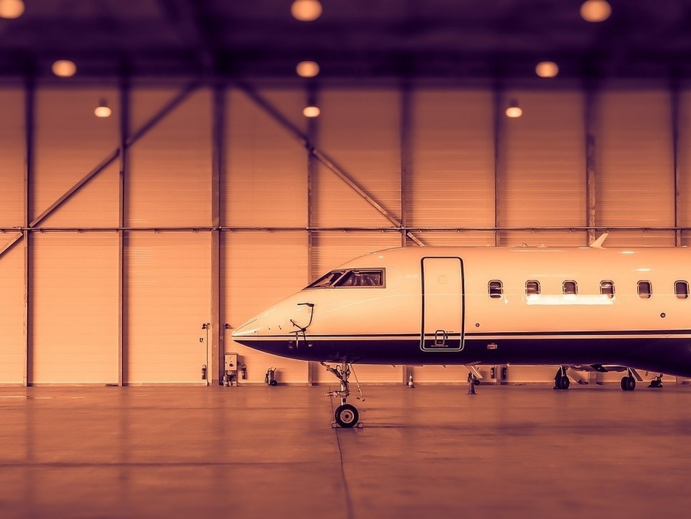 A Bombardier private jet parked in an empty hangar