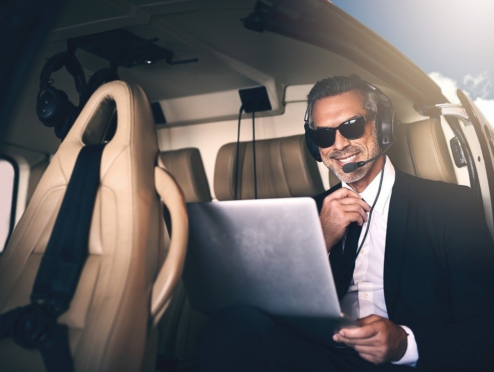 A corporate helicopter user works on his laptop