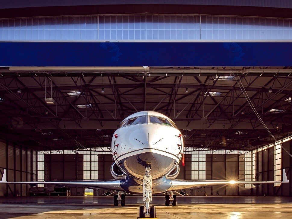 A large private jet parked in front of an empty hangar