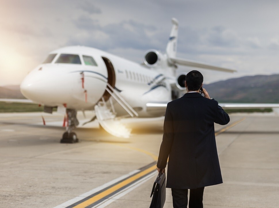Businessman walks towards a Dassault Falcon private jet