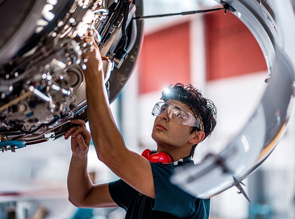 Young mechanic inspecting a private jet engine