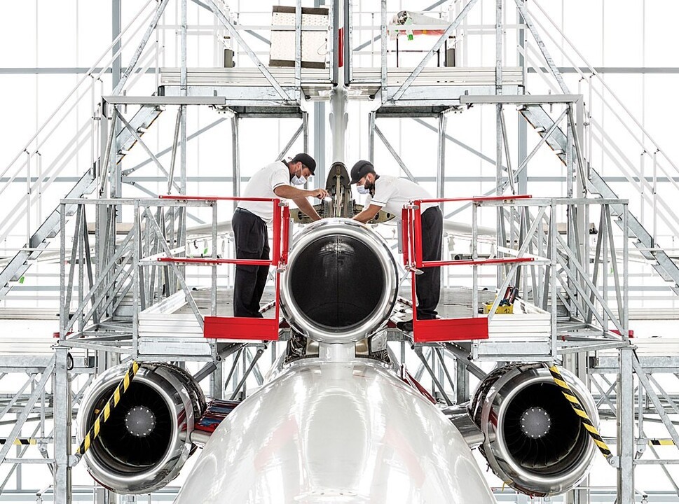 Two mechanics work on a new-build Dassault Falcon Jet