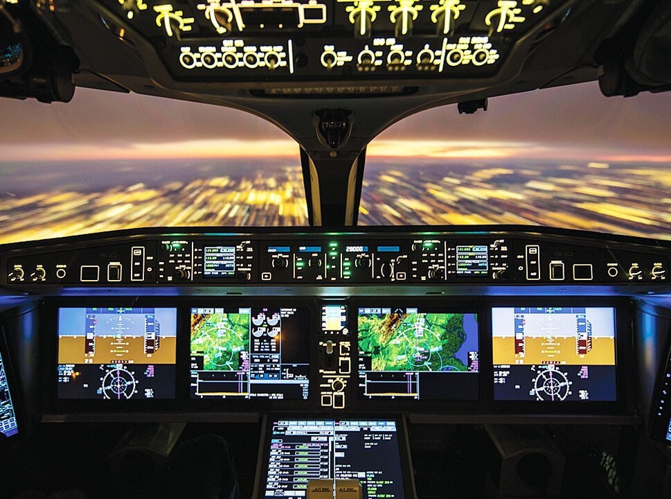 Modern private jet flight deck lit up at night