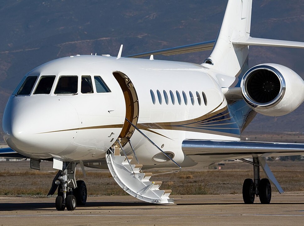 A Dassault Falcon jet with open airstairs waiting for passengers